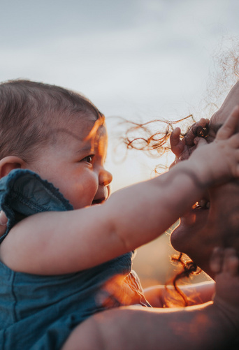 baby girl reaching for her mom